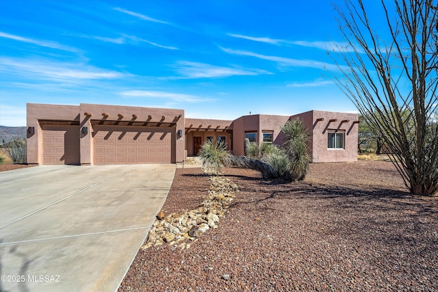 southwest-style home featuring a garage, driveway, and stucco siding