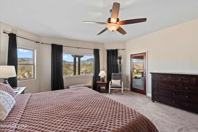 bedroom featuring light carpet, ceiling fan, multiple windows, and access to exterior