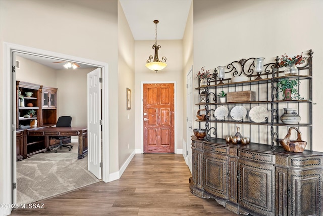 foyer featuring a high ceiling, wood finished floors, and baseboards