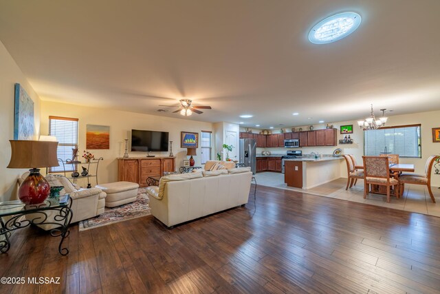 living room with recessed lighting, hardwood / wood-style floors, and ceiling fan with notable chandelier