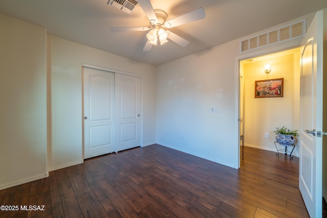 unfurnished bedroom with baseboards, visible vents, and dark wood-style flooring