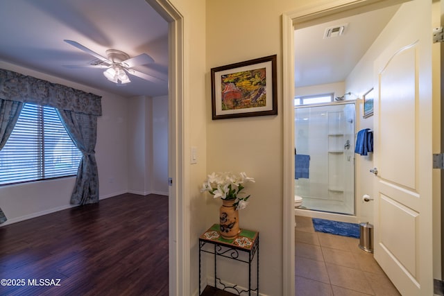 hall with baseboards, visible vents, a wealth of natural light, and tile patterned floors