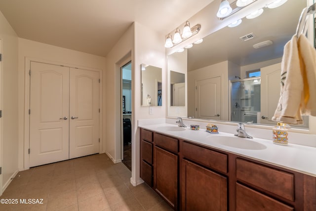 full bath featuring visible vents, a sink, a shower stall, and tile patterned floors