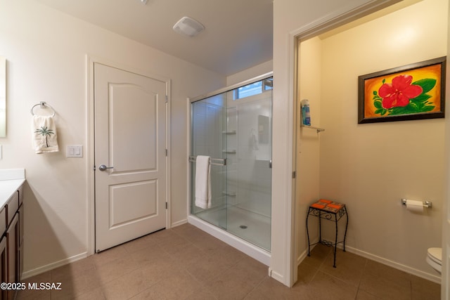 full bathroom with toilet, vanity, baseboards, a shower stall, and tile patterned floors