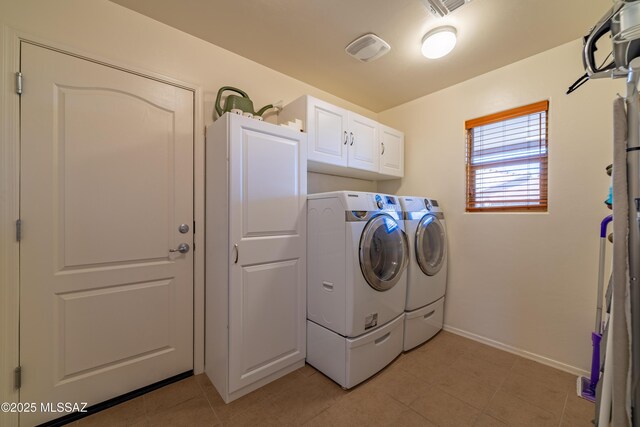 laundry area with light tile patterned floors, cabinet space, visible vents, baseboards, and washer and dryer