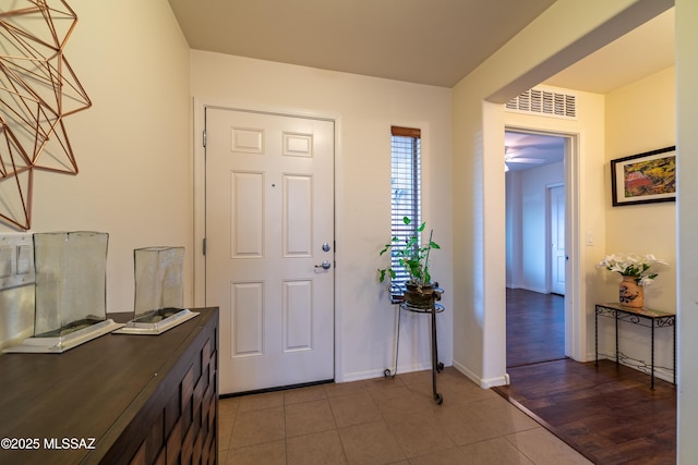 foyer entrance with baseboards, visible vents, and tile patterned floors