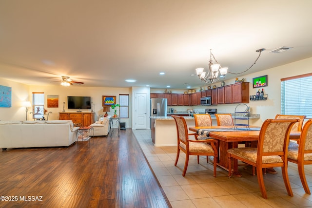 dining room featuring recessed lighting, visible vents, light wood-style flooring, and ceiling fan with notable chandelier