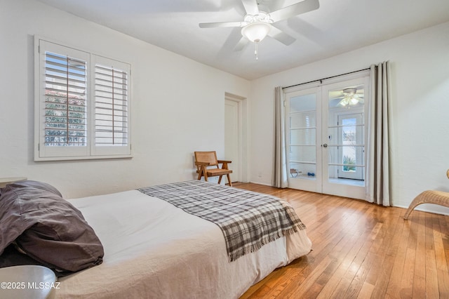 bedroom with light wood-style floors, ceiling fan, and french doors