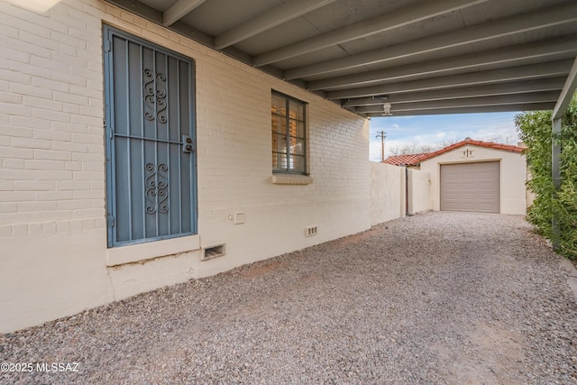 exterior space with brick siding, crawl space, and gravel driveway