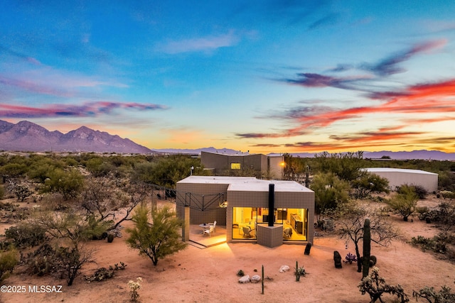 back of house at dusk featuring a mountain view