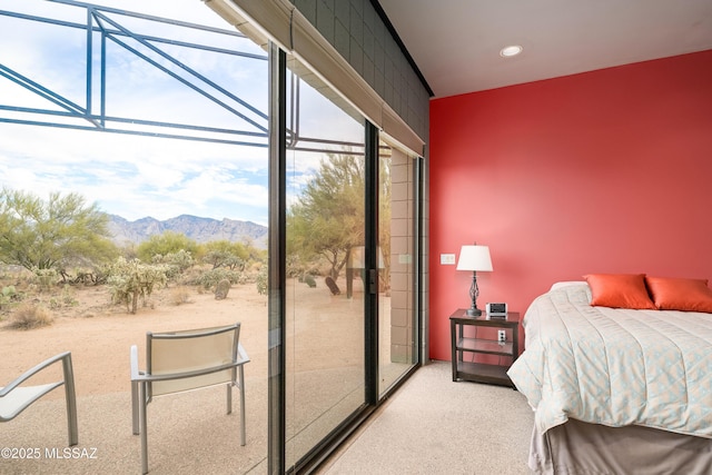 carpeted bedroom featuring access to exterior, multiple windows, and a mountain view