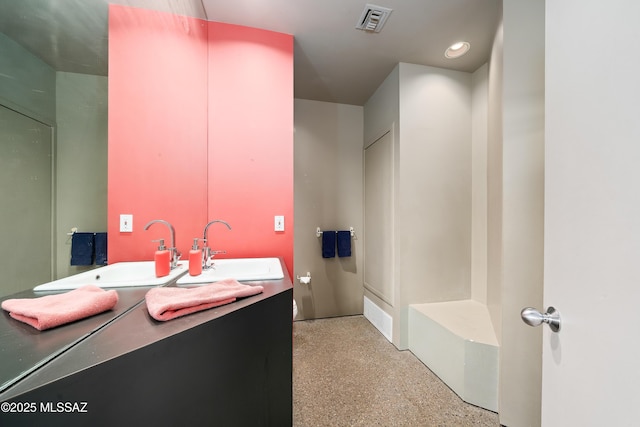 full bathroom with double vanity, speckled floor, visible vents, and a sink