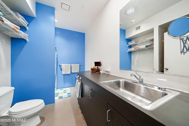 interior space featuring vanity, toilet, recessed lighting, and visible vents