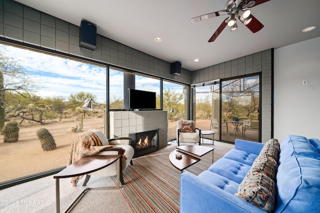 carpeted living area with recessed lighting, a healthy amount of sunlight, and a tile fireplace