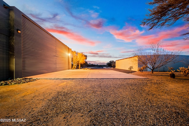 yard at dusk featuring a patio area