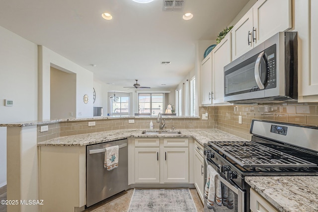 kitchen featuring stainless steel appliances, visible vents, a sink, and decorative backsplash