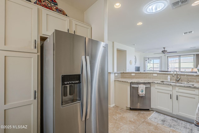 kitchen featuring stainless steel appliances, visible vents, a sink, and tasteful backsplash