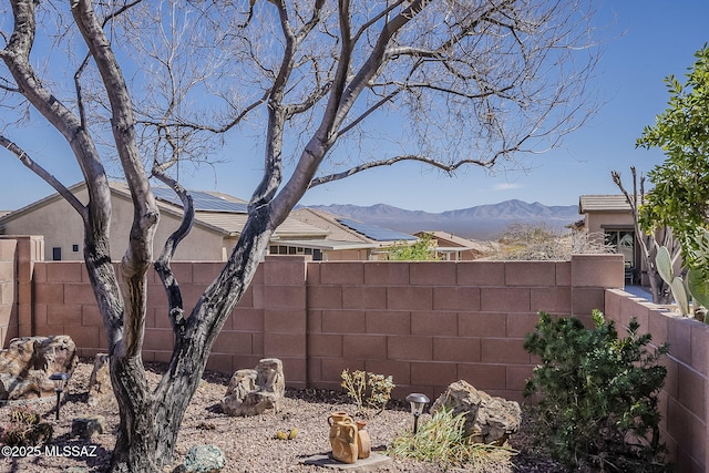 view of yard with a fenced backyard and a mountain view