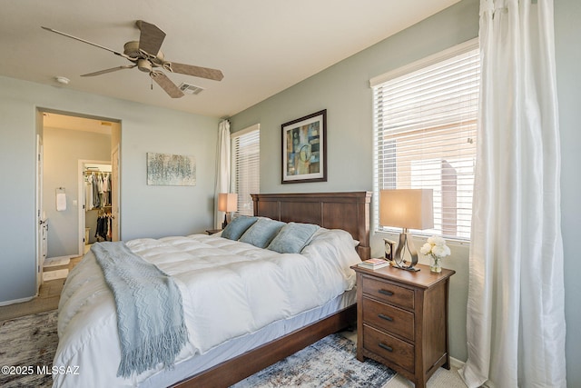 bedroom featuring baseboards, a spacious closet, visible vents, and a ceiling fan