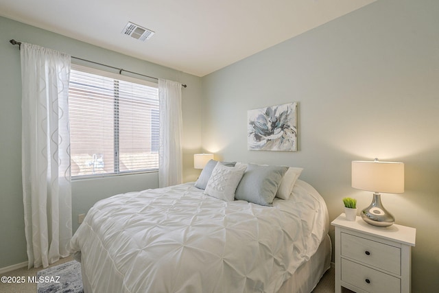 bedroom featuring baseboards and visible vents