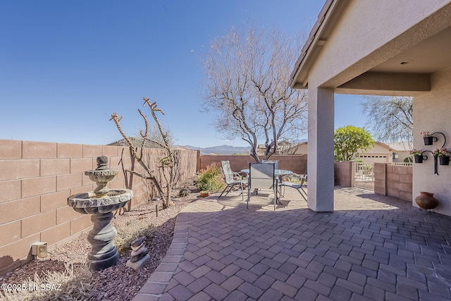 view of patio featuring outdoor dining space, a fenced backyard, and a gate