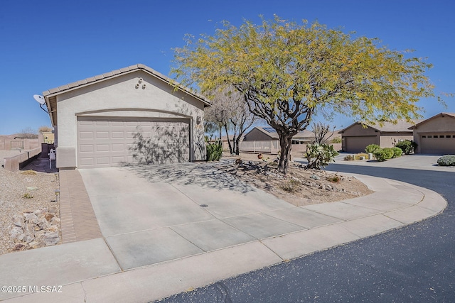 view of front of house featuring driveway, a tiled roof, and stucco siding