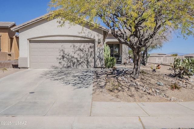 view of front of property with a garage, a tile roof, driveway, and stucco siding