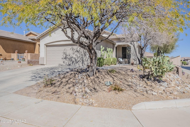 view of front of property with a garage, driveway, a tiled roof, and stucco siding