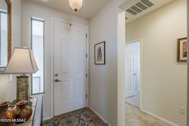 foyer entrance with visible vents and baseboards