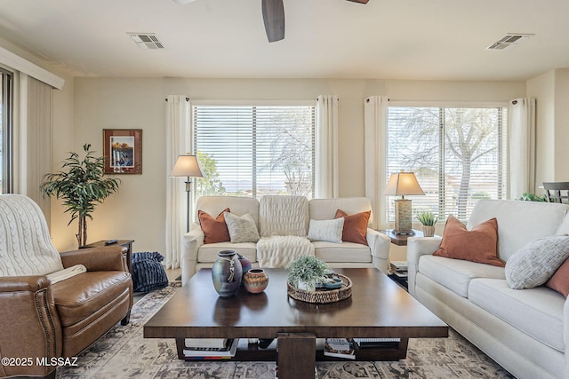 living room with a healthy amount of sunlight, visible vents, and a ceiling fan