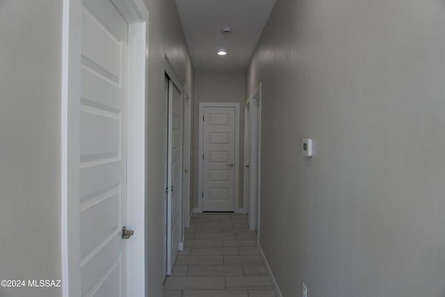 corridor featuring baseboards and recessed lighting