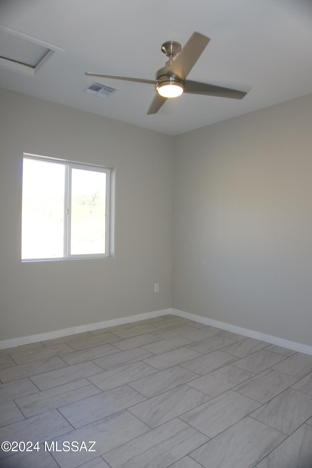 spare room featuring attic access, visible vents, baseboards, and a ceiling fan