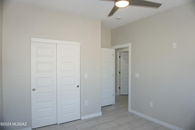 unfurnished bedroom with a closet, ceiling fan, and baseboards
