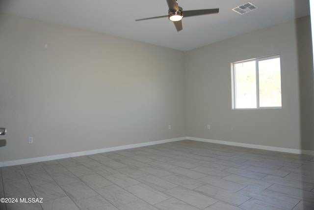 empty room with visible vents, ceiling fan, and baseboards