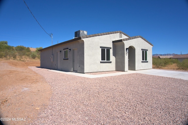 view of front of property featuring central AC unit and stucco siding