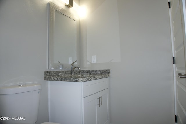 half bathroom featuring toilet and vanity