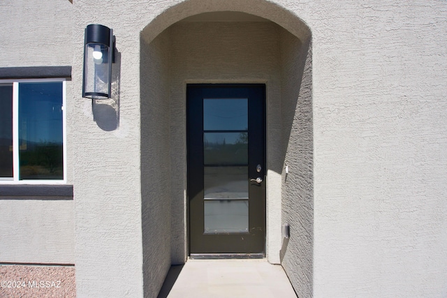 view of exterior entry with stucco siding