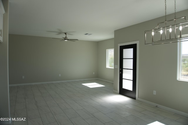 spare room featuring ceiling fan, visible vents, and baseboards
