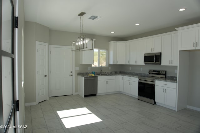 kitchen featuring white cabinets, stone counters, visible vents, and stainless steel appliances