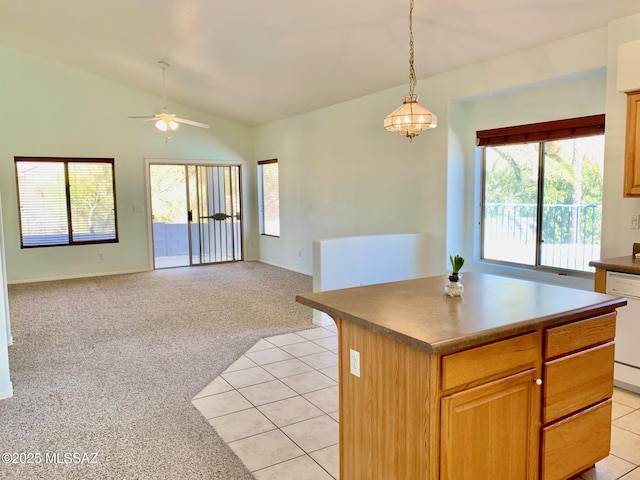 kitchen featuring light carpet, light tile patterned floors, white dishwasher, and vaulted ceiling