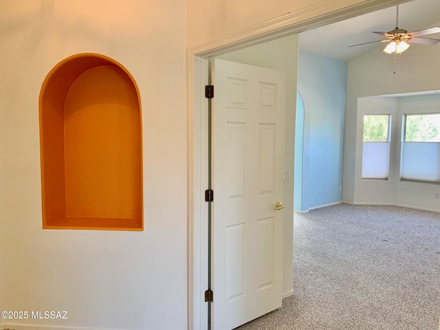 hallway featuring carpet floors and baseboards