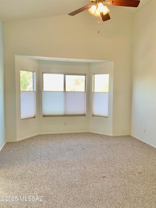 carpeted empty room featuring ceiling fan and baseboards