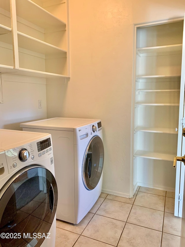 washroom with washer and dryer, laundry area, baseboards, and light tile patterned floors