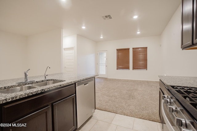 kitchen featuring light stone counters, light carpet, a sink, visible vents, and appliances with stainless steel finishes