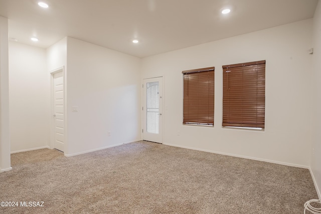 carpeted spare room featuring baseboards and recessed lighting