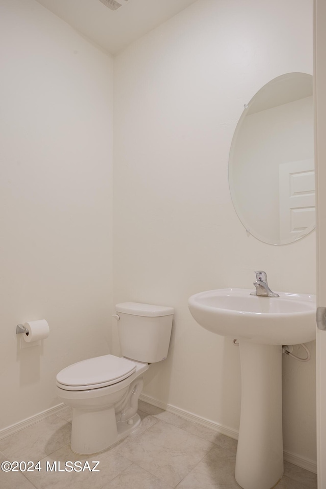 bathroom with toilet and baseboards