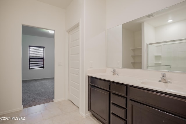 full bathroom featuring double vanity, tile patterned flooring, a sink, and baseboards