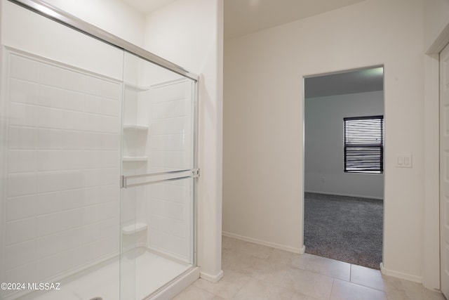 full bathroom with a shower stall, baseboards, and tile patterned floors