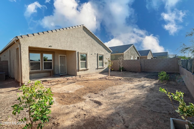 back of house featuring a patio, cooling unit, a fenced backyard, and stucco siding