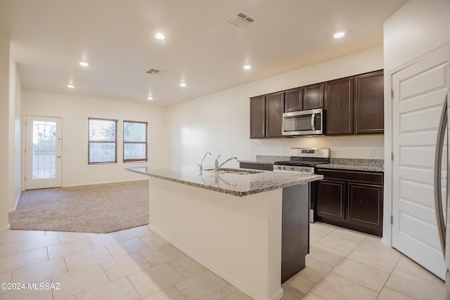 kitchen with light carpet, a sink, visible vents, appliances with stainless steel finishes, and light stone countertops